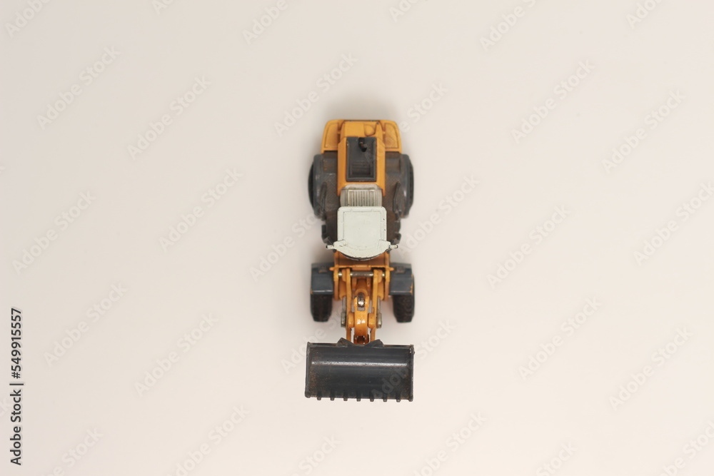 Fototapeta premium a close up of miniature orange wheel loader toy