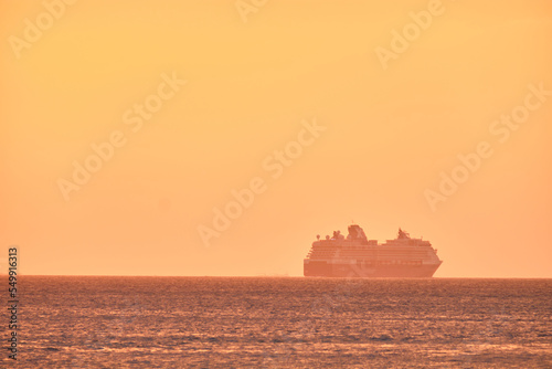 Boracay, Philippines - Jan 23, 2020: Sunset on Boracay island. Sailing and other traditional boats with tourists on the sea against the background of the setting sun. Celebrity Millennium cruise ship