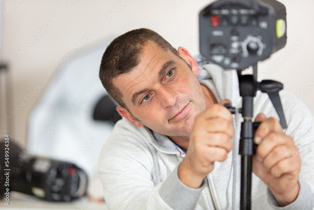 photographer adjusts the height of studio spotlight photographer adjusts the height of studio spotlight
