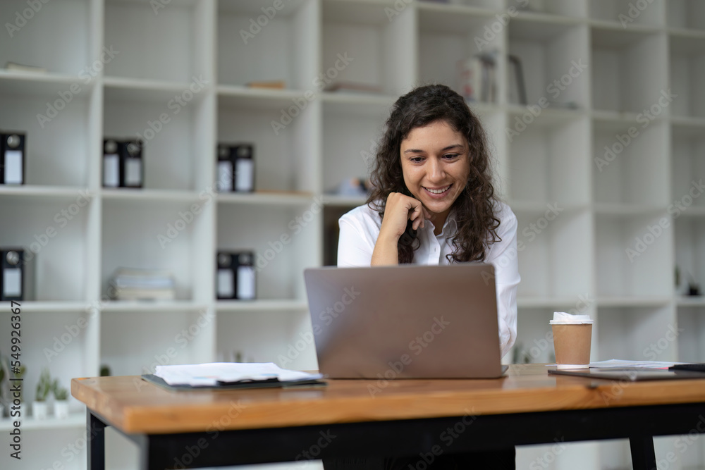 Confident businesswoman working on laptop at her workplace at modern office.