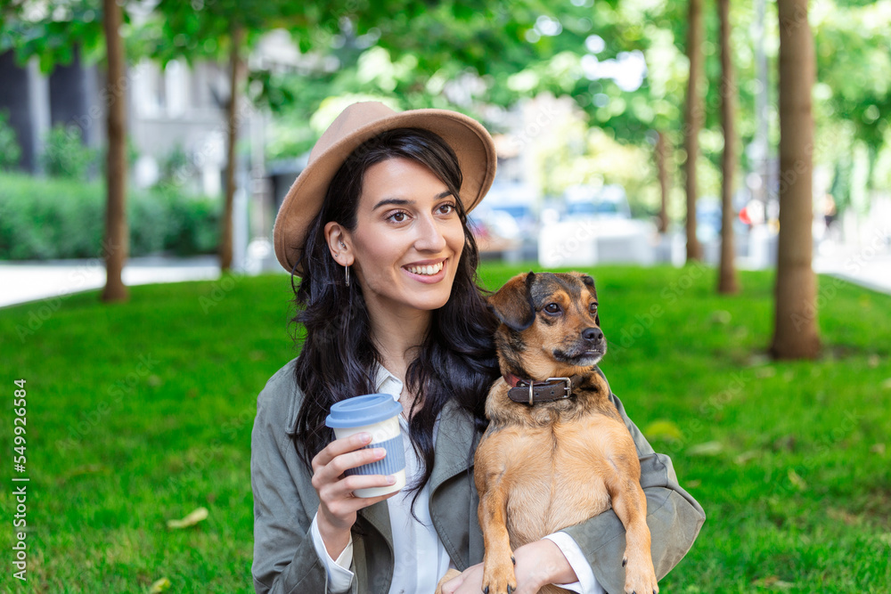 happy hipster woman playing with her dog and drinking coffee. stylish girl with funny dog resting, hugging and having fun in sun, cute moments. space for text