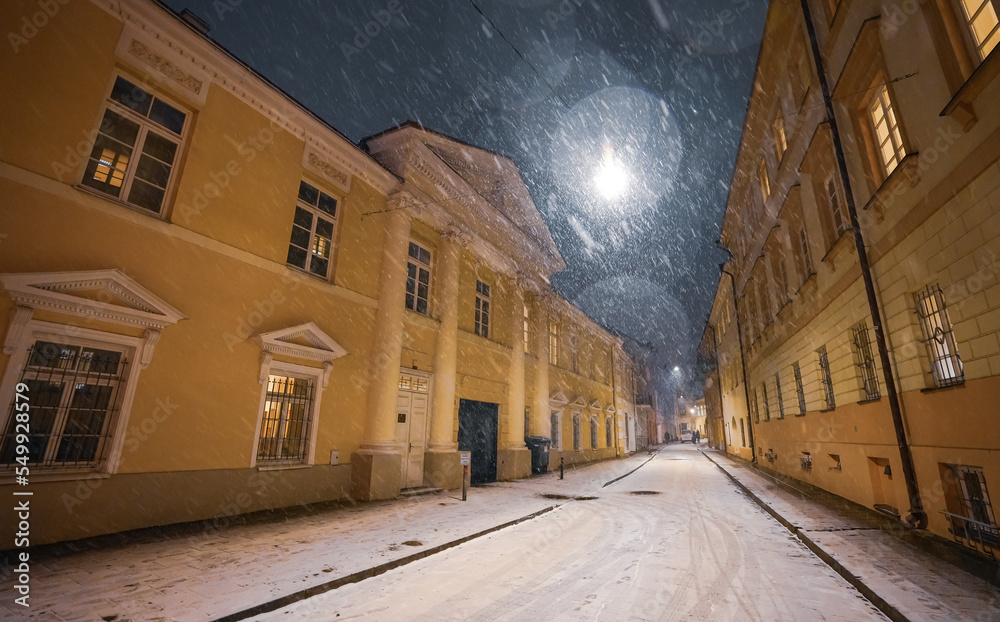 Winter snowfall on the streets of Vilnius. Cityscape photo with calm beautiful snow falling from the sky during an evening in Lithuania, 2022.