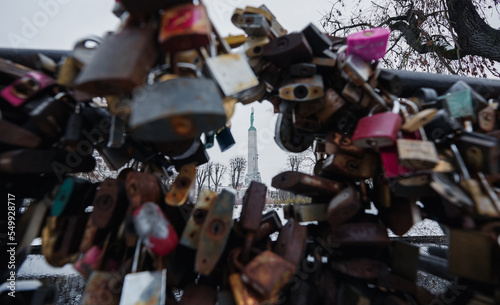 Concept photo with the Freedom Liberty Monument from Riga, photographed through a lot of locks placed on a bridge. Latvia, 2022.