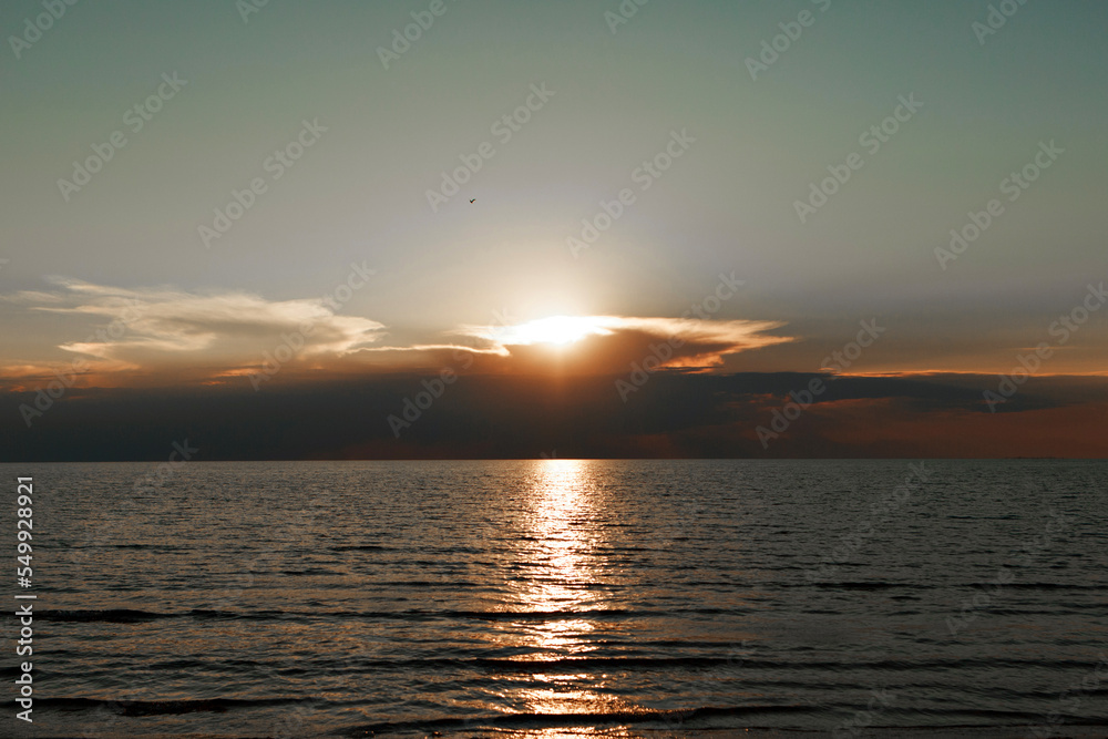 Waves on the sea during sunset. Relaxation, enjoyment. Journey to the ocean, peace and happiness. Colorful, bright, orange sunset. The sun shines through the clouds on the ocean. Beautiful wallpapers Waves on the sea during sunset. Relaxation, enjoyment. Journey to the ocean, peace and happiness. Colorful, bright, orange sunset. The sun shines through the clouds on the ocean. Beautiful wallpapers