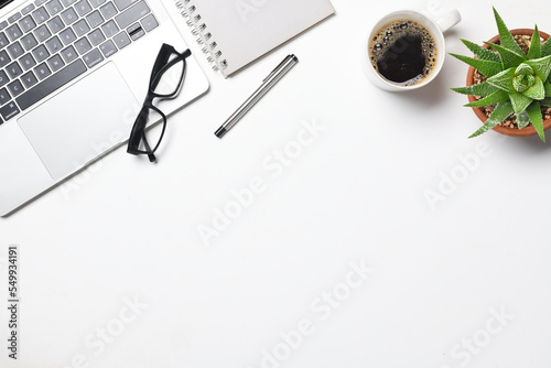 Flat lay White office desk table with Laptop, coffee, eyeglasses  on white background. photo