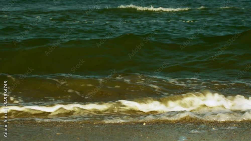 Closeup of sea weaves crushing on the shore. White foam. Beautiful summer day. A sunny warm day on the beach Closeup of sea weaves crushing on the shore. White foam. Beautiful summer day. A sunny warm day on the beach