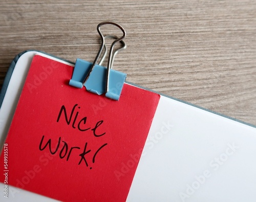 Red note on document with handwriting praise NICE WORK!, concept of giving positive feedback in response to a job well done, compliment to staff from boss or clients, from teacher to student