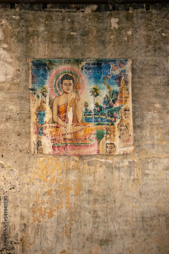 old painted print of buddha on decayed wall in asia