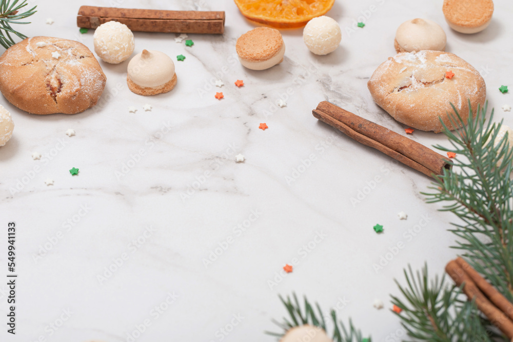 Fototapeta premium candies and cookies with christmas tree branches on white marble background