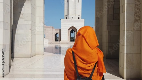 woman walking with orange hijab in mosque