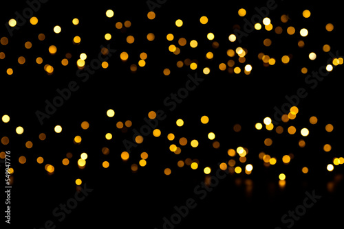 Blak background with golden bokeh light. Holiday glowing backdrop. Defocused Background With yellow spots. Blurred Bokeh. Christmas party concept. Copy space. photo