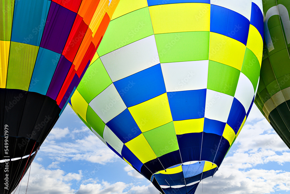 Obraz premium Colorful hot air balloon flying over blue sky with white clouds 