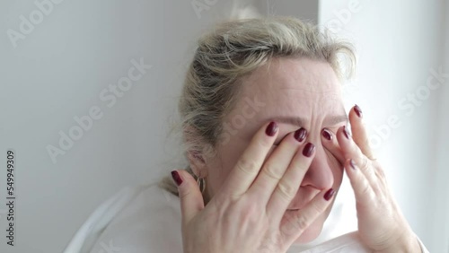 A woman rubs her eyes after the procedure