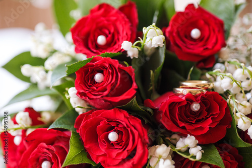 Hochzeitsringe auf roten Rosen und Maigl  ckchen
