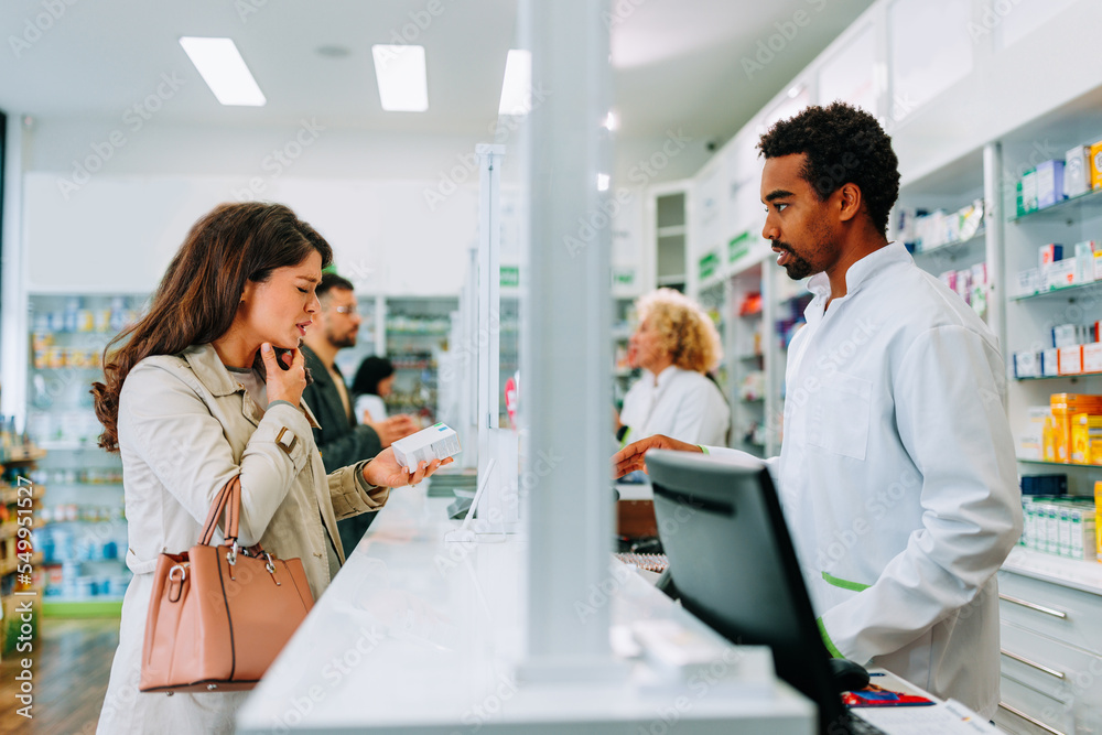Obraz premium Woman purchasing cough medication in pharmacy.