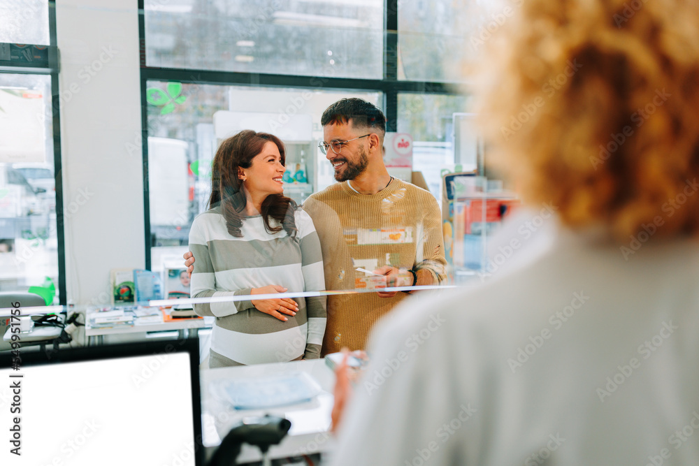 Obraz premium Pregnant woman with husband in pharmacy.