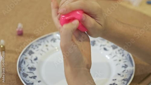 funny childhood experiences. child playing hand made toy called slime. Hand holding homemade toy called slime. Kid having fun and being creative by science experiment. photo