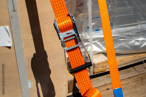 Tension safety belts with mechanical locks. On a pallet or in a container box, the cargo is held by tension safety belts with mechanical locks and ratchet Straps.