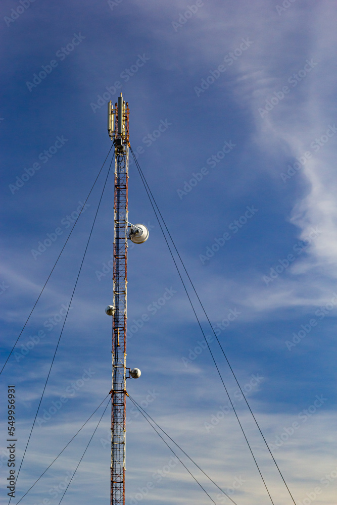 Telecommunication tower for mobile phone with antennas over a blue sky. Distribution function of contract mobile phones Telecommunication tower for mobile phone with antennas over a blue sky. Distribution function of contract mobile phones