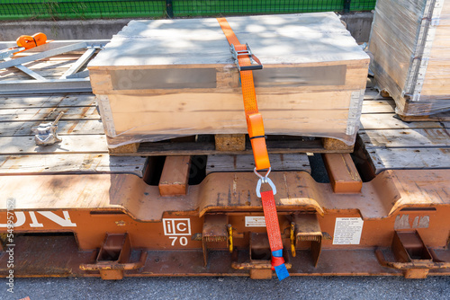 Tension safety belts with mechanical locks. On a pallet or in a container box, the cargo is held by tension safety belts with mechanical locks and ratchet Straps. photo