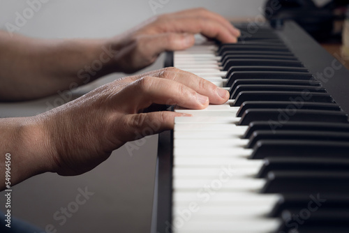 Detail of a man playing a midi keyboard