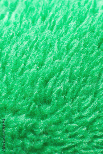 Green fluffy textile texture. Nappy hairy background closeup.