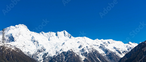 The mountain view of alpine as snow-capped mount peaks in  Swiss Mountain alps against the blue sky background © SASITHORN