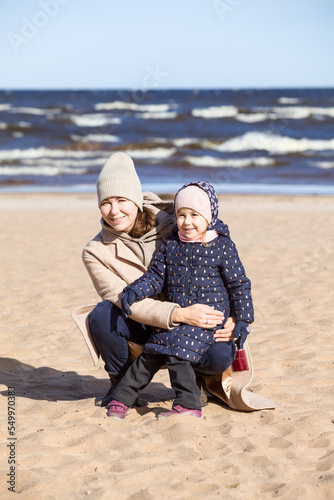 Portrait of a mother with a three-year-old daughter, sandy beach © Kekyalyaynen