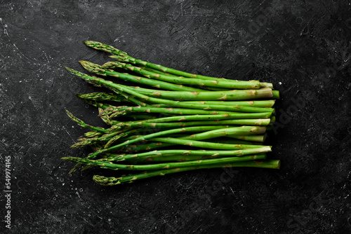 Organic food. Green asparagus on a black stone table. On a stone background. Top view.