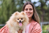 Portrait of a girl posing with her pomeranian dog in a park. Close up .Dog posing with her tongue out