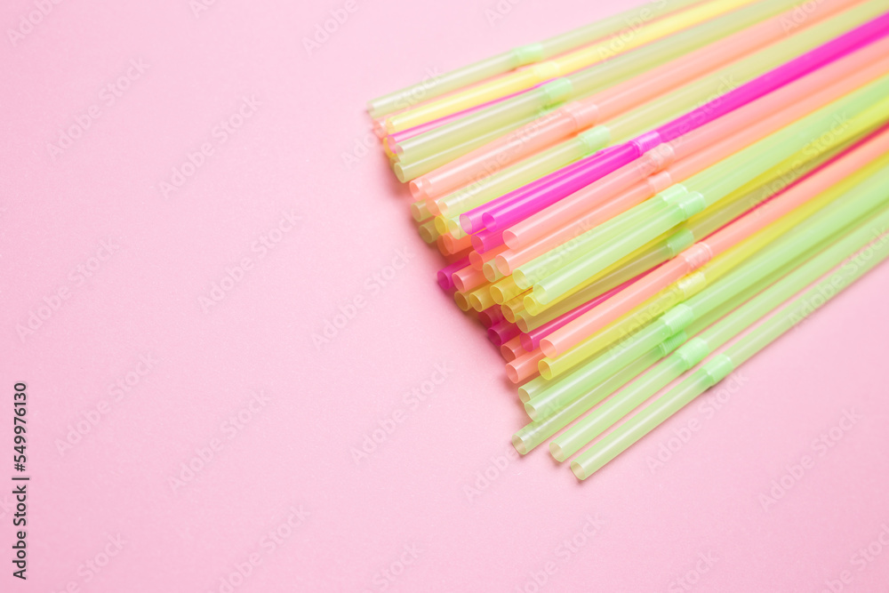 Colored cocktail straws close-up on a pink isolated background Colored cocktail straws close-up on a pink isolated background