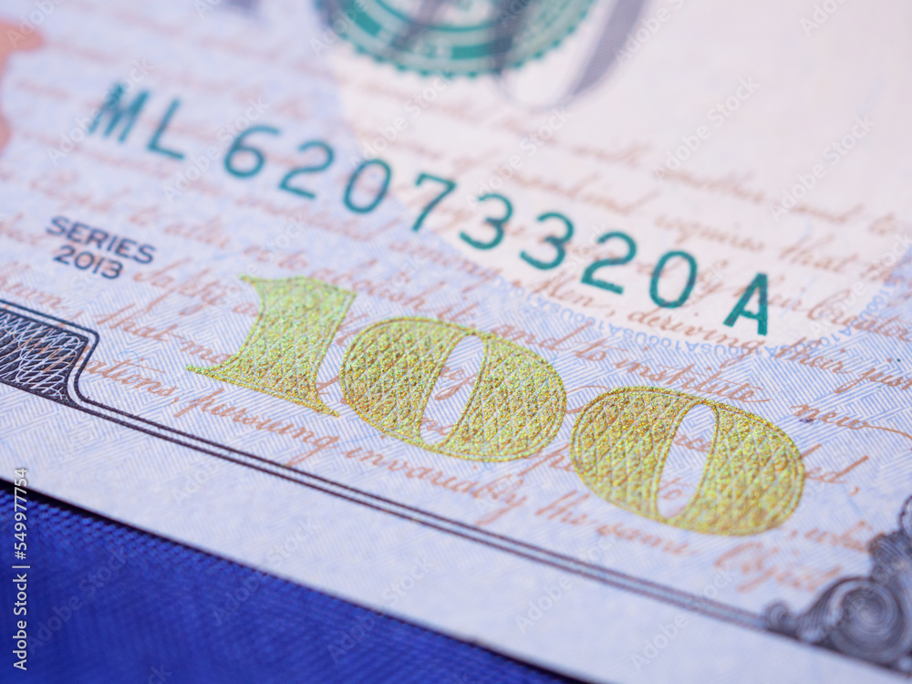 Obraz premium Close up, American one hundred dollar banknote on blue background. Selective focus. Close-up money background. Business, finance, investment and savings concept. .