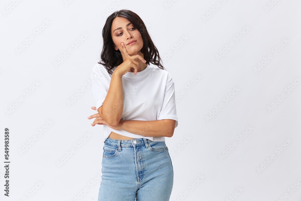 Woman in white t-shirt on white background brunette hands up gestures and signals poses in jeans emotion, lifestyle smiles, copy space Woman in white t-shirt on white background brunette hands up gestures and signals poses in jeans emotion, lifestyle smiles, copy space