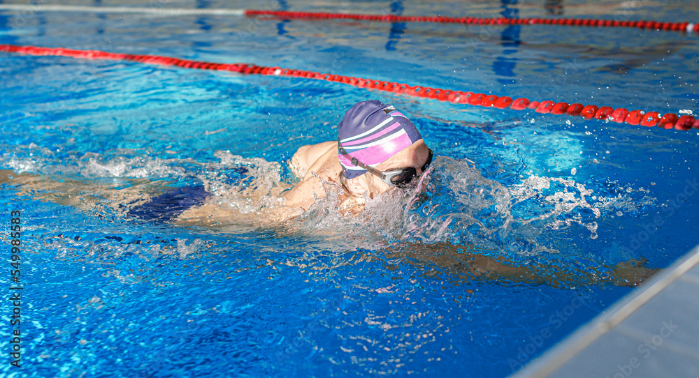 Swimmer in the pool. A male athlete is engaged in swimming in a sports pool.