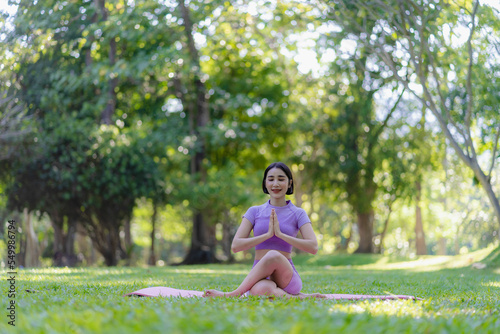 Fitness woman doing yoga in park, calm and relaxing women's happiness blurry background Asian woman meditating while practicing yoga concept of freedom peace and relaxation healthy