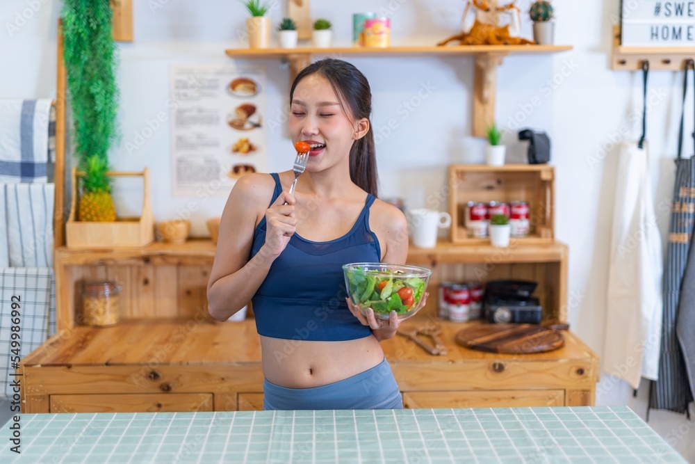 Young beautiful asian female adult lady in gym outfit after yoga exercise. Eat clean food salad with tomato for healthy and slim fit lifestyle. Young beautiful asian female adult lady in gym outfit after yoga exercise. Eat clean food salad with tomato for healthy and slim fit lifestyle.