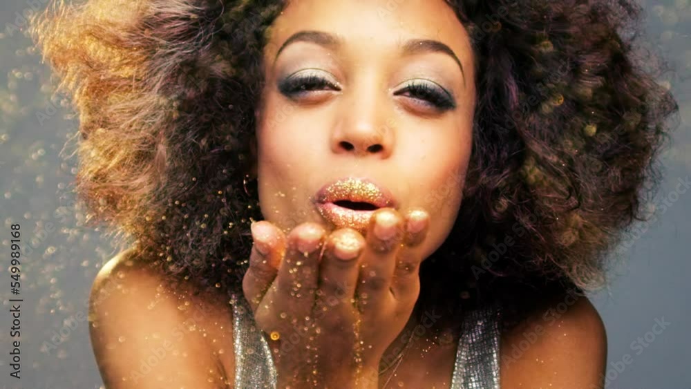Black woman, glitter and blowing hands of confetti, new year celebration and fun party, sparkles and shine on studio background. Portrait of girl model celebrate with gold dust, happy event and magic