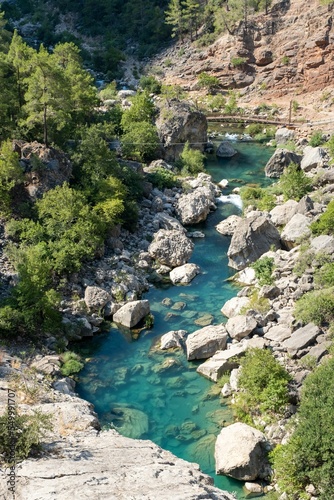 Vertical high angle of the blue lagoon from the Yerkopru Waterfall around rocks in Turkey photo