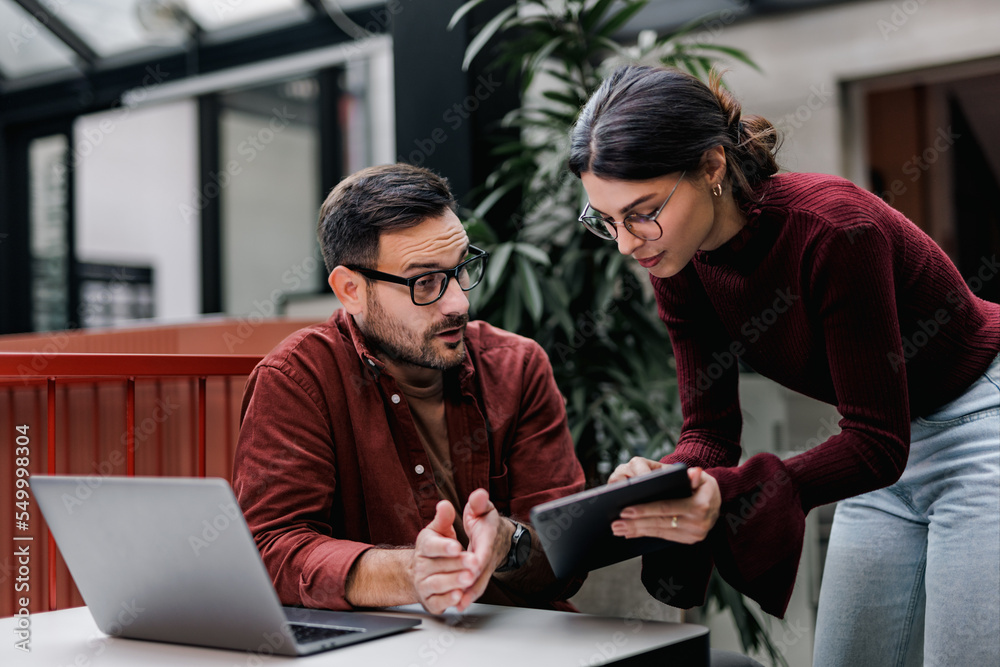 Business people working together, female showing something over the tablet. Business people working together, female showing something over the tablet.
