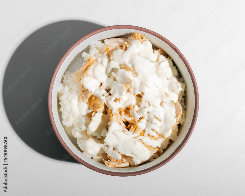 Chicken with rice and white sauce in oriental style closeup isolated top view Chicken with rice and white sauce in oriental style closeup isolated top view
