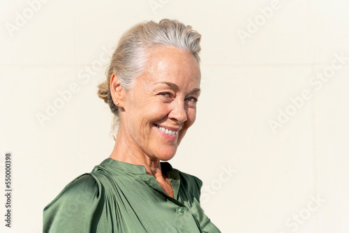 Smiling mature woman with wrinkles on sunny day