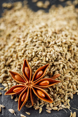 aromatic dry anise seeds on a dark black stone background
