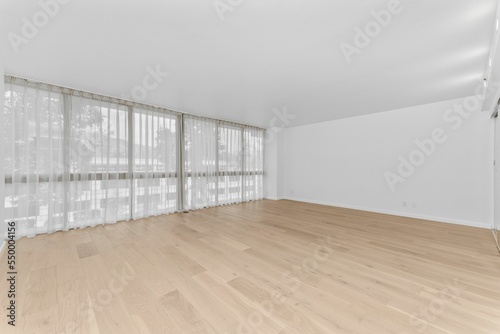 Interior view of an empty room with white walls and a wooden floor in California, USA