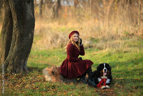 November 23, 2022. Vinnytsia, Ukraine: A girl walks with her purebred dog in autumn in the park and looks at the sky