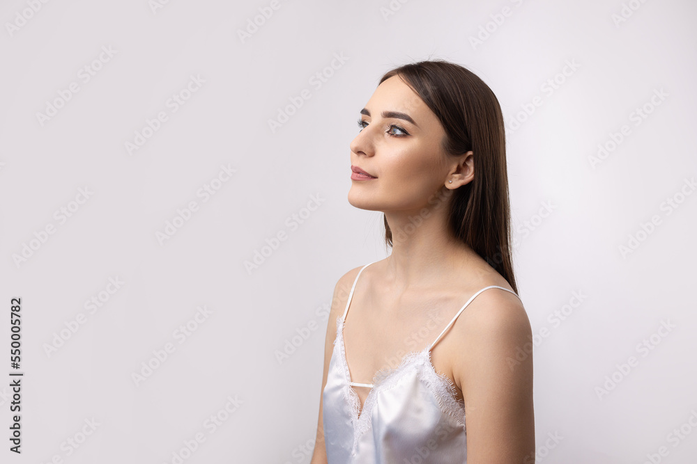 Beautiful smiling woman with clean skin, natural make-up and white teeth on a gray background