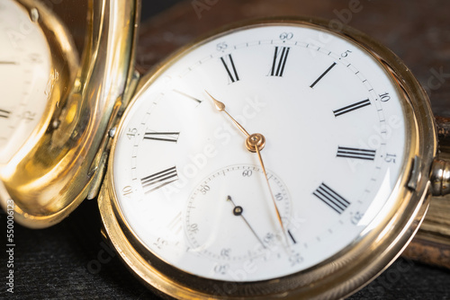 Gold pocket watch "Pavel Bure" on a gold pendant. Royal Russia. pocket watch on a dark background with books 