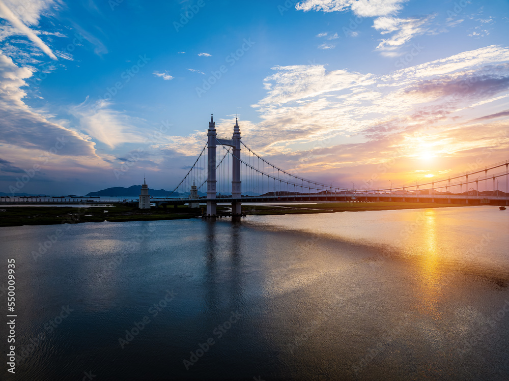 Obraz premium Aerial view of beautiful bridge and river natural scenery at sunset in Zhoushan, Zhejiang, China.