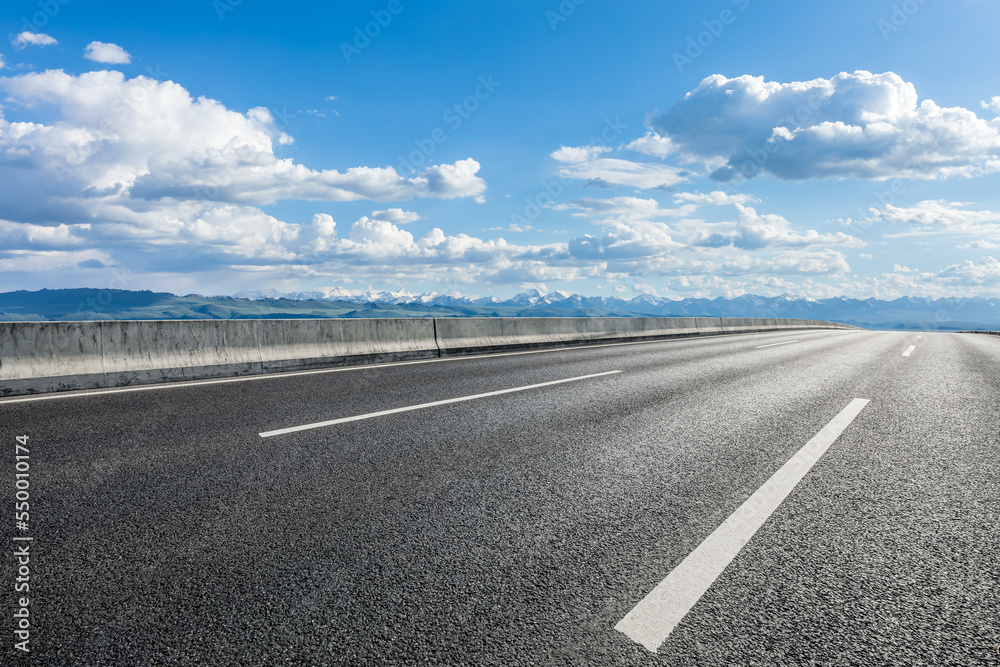 Country road with mountain scenery under blue sky Country road with mountain scenery under blue sky