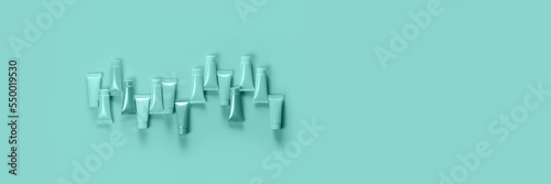 Empty tubes for the design of cosmetics on the blue background. Female cosmetics. Tubes for cream, liquids, pastes and gel. Banner.