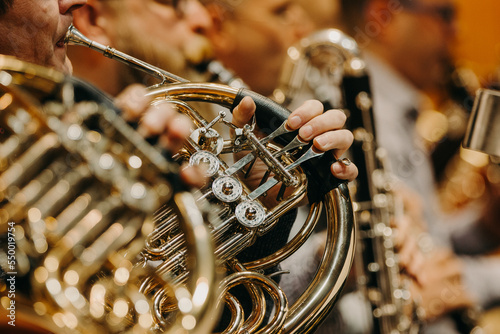 Close up of hand on the french horn during philharmonic concert, art concept photo